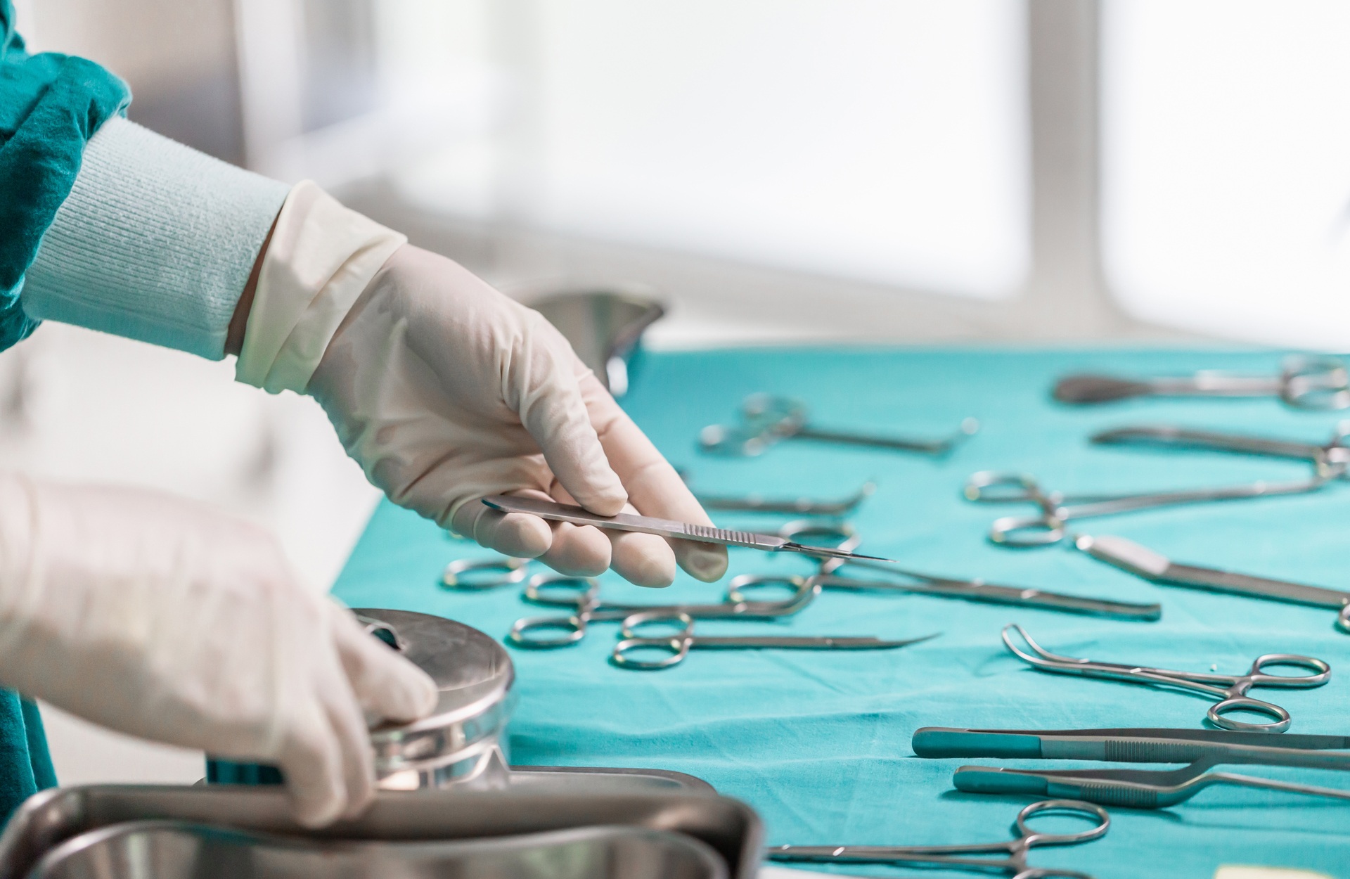 Doctor holds surgical instruments in hand, Surgeons hands with scalpel at operation in operating room Free Photo